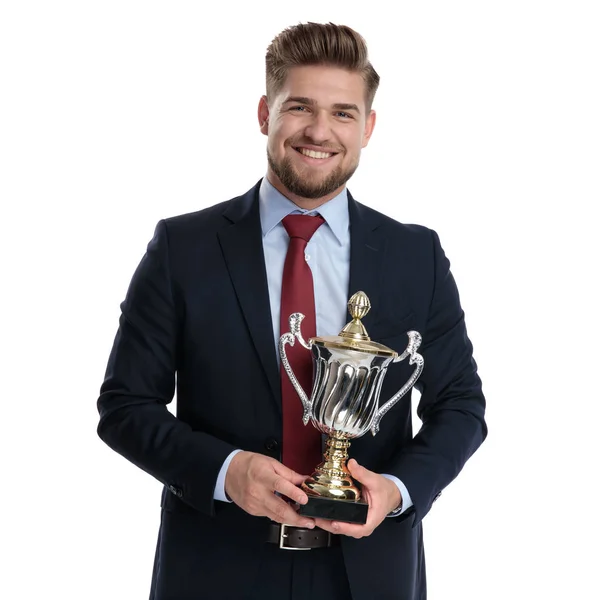 Hrdý obchodník, který drží trofej a usmívá se — Stock fotografie