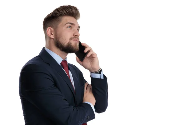 Esperanzado hombre de negocios hablando por teléfono y mirando hacia arriba — Foto de Stock