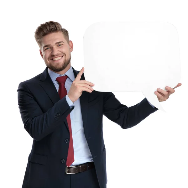 Empresário positivo segurando uma bolha de discurso em branco e rindo — Fotografia de Stock