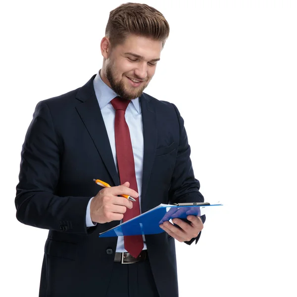 Un hombre de negocios seguro a punto de escribir en su portapapeles — Foto de Stock