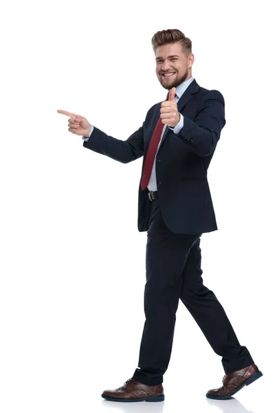 Feliz hombre de negocios pisando y señalando mientras gesticulando ok — Foto de Stock