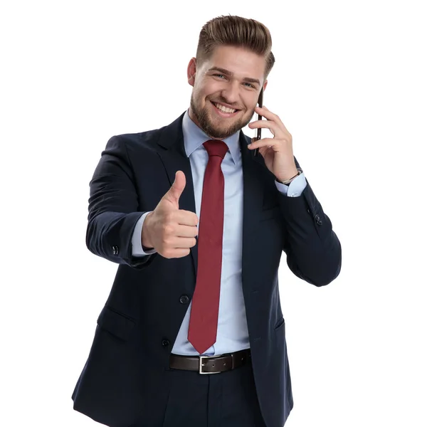 Empresário atraente gesticulando ok e falando em seu telefone — Fotografia de Stock