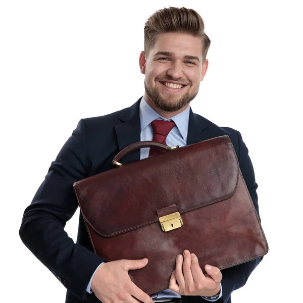 Jolly hombre de negocios sosteniendo su maletín y sonriendo — Foto de Stock