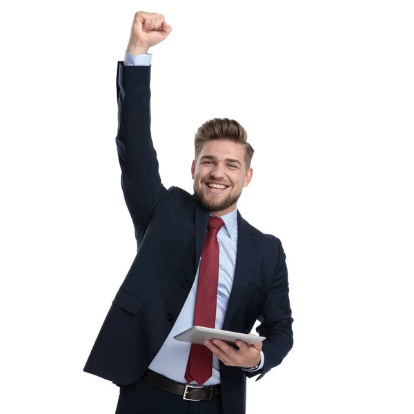 Joven hombre de negocios celebrando y sosteniendo su tableta — Foto de Stock