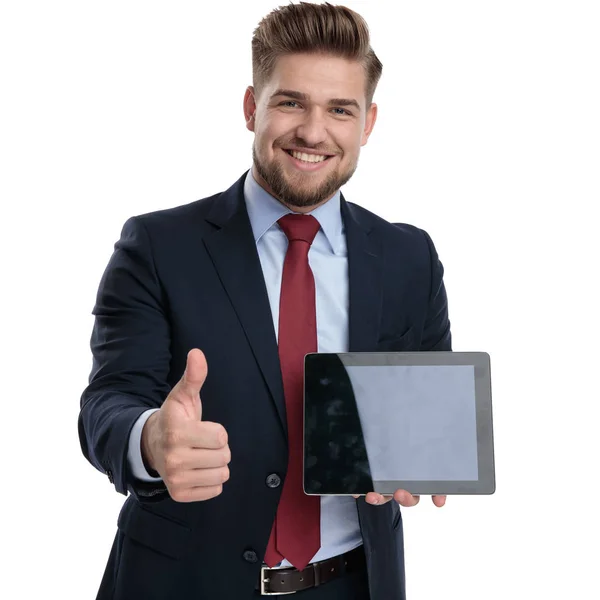 Hombre de negocios guapo gesticulando bien y sosteniendo su tableta — Foto de Stock