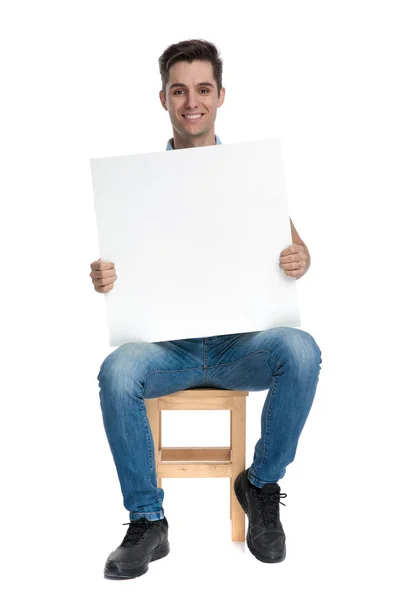 Positive young man holding an empty billboard Royalty Free Stock Photos