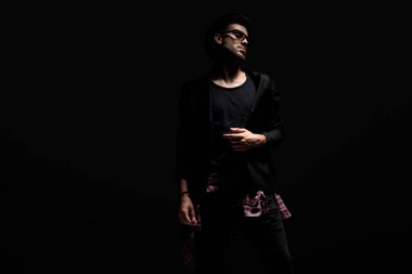 Dramatik adam ceketini ayarlıyor ve yan bakıyor