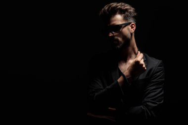 Düşünceli gizemli adam uzağa bakıyor ve ellerini fotutarak