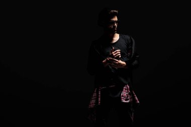 Dramatik adam bileziği ayarlayan ve yan bakıyor