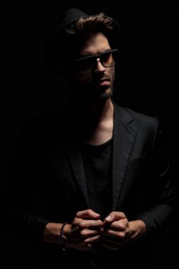 Dramatik genç adam ayarlama ve ceketini çekerek 