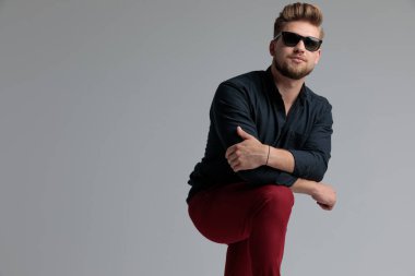 Kendine güvenen rahat adam bacağına yaslanmış