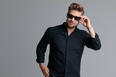 Kendinden emin rahat adam onun güneş gözlüğü ayarlama