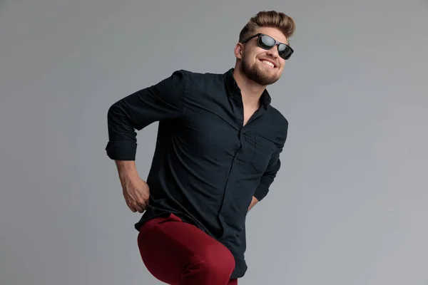 Positivo casual hombre riendo y tirando de sus pantalones rojos —  Fotos de Stock