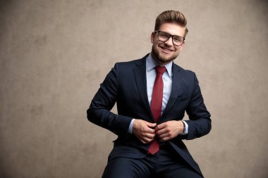 Pozitif işadamı ceketini ayarlayıp gülüyor 
