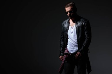 Güneş gözlüğü takarken düşünceli rock adam adım