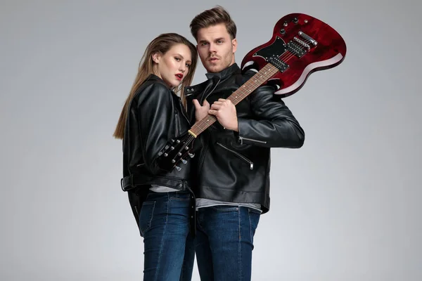 Casal de rock posando enquanto ela está puxando seu casaco — Fotografia de Stock