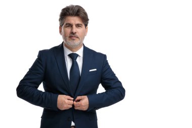 Üst düzey işadamı ceketinin düğmelerini ayarlıyor