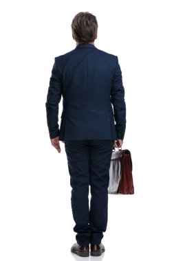 Çantasını tutan ciddi bir işadamının arka görünümü