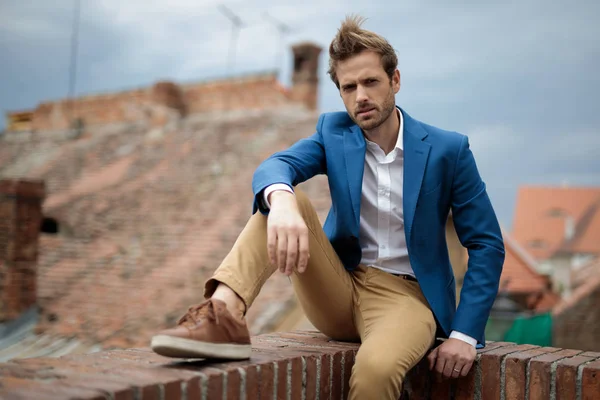 Jeune homme décontracté intelligent reposant sur un mur de briques — Photo