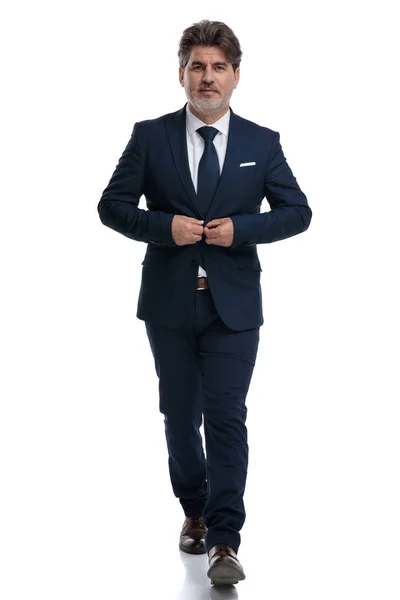 Elegante zakenman die naar voren loopt en zijn jas fixeer — Stockfoto