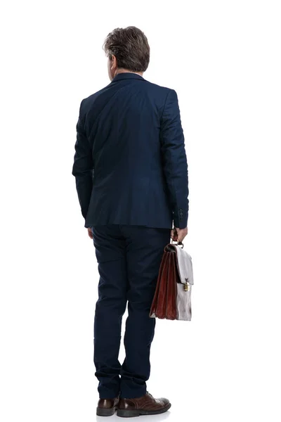 Back view of an old businessman holding his suit case — Stock Photo, Image