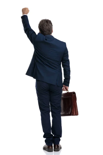 Back view of a businessman celebrating and holding his suitcase — Stock Photo, Image