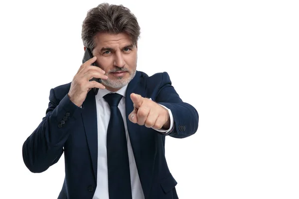 Elegant businessman pointing and talking on his phone — Stock Photo, Image