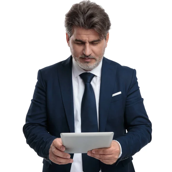 Hombre de negocios enfocado leyendo en su tableta — Foto de Stock