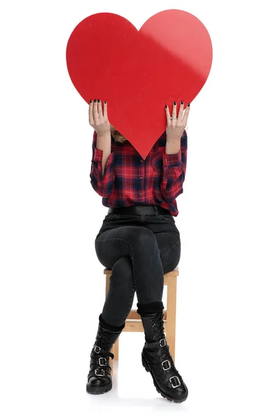 Příležitostná žena, která sedí s tváří zakrytou srdcem — Stock fotografie