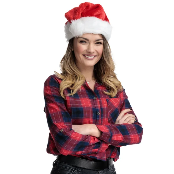 Случайная женщина с рождественской шляпой и скрещенными руками, глядя вперед — стоковое фото