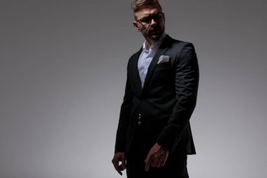 adam serbestçe ellerini tutarak ve pensively uzağa bakıyor