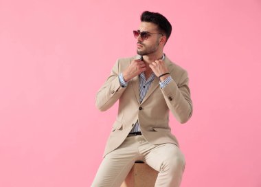 akıllı rahat adam ahşap bir kutu üzerinde oturan onun yaka sabitleme