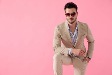 çekici genç adam diz üzerine dirsek eğilerek