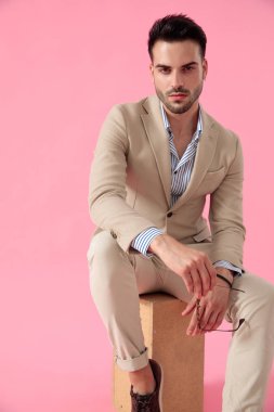 ahşap kutu üzerinde oturan baştan çıkarıcı genç adam