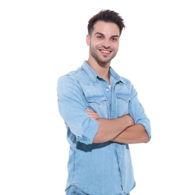 denim giyen ve kollarını geçen yakışıklı genç adam
