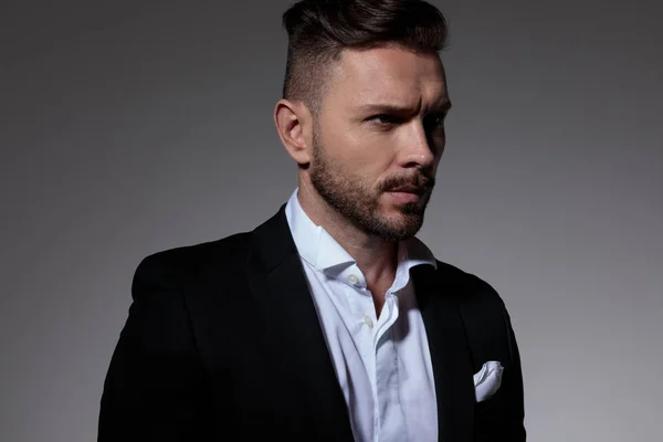 handsome business man in tuxedo looking away pensively