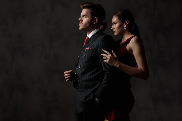 Hombre con la mano en el bolsillo y mujer sosteniendo su brazo — Foto de Stock