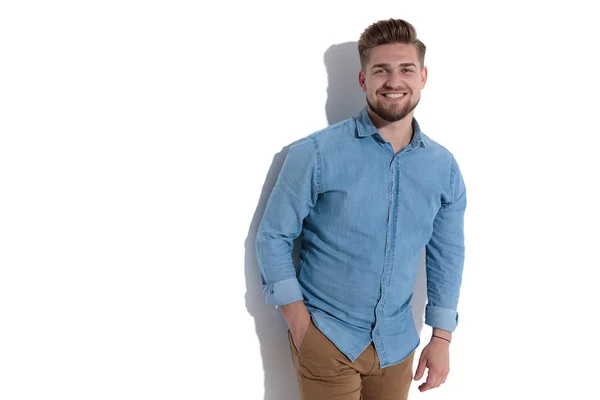 Joven feliz hombre casual de pie con la mano en el bolsillo — Foto de Stock