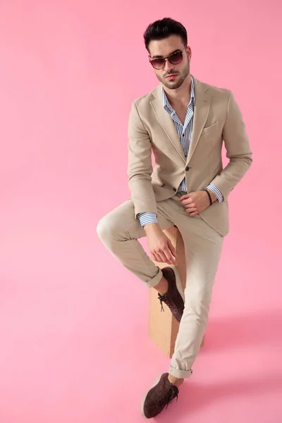 Smart casual man seated on a wooden box — Stock Photo, Image