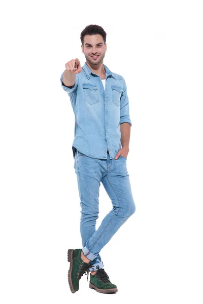 Casual young man wearing denim and pointing finger — Stock Photo, Image