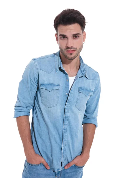 Привлекательный молодой человек в джинсе, позирующий с руками в карманах — стоковое фото