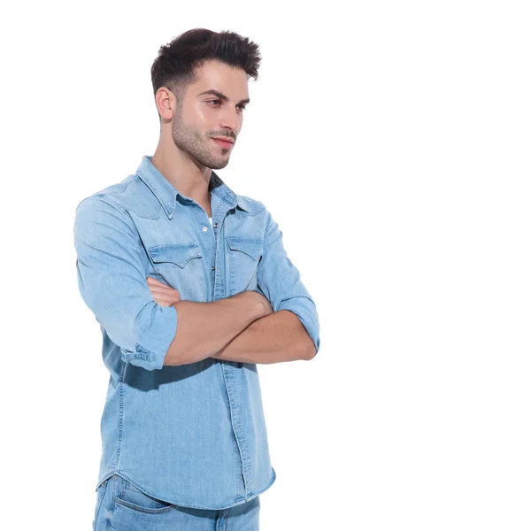 Jeune homme détendu portant le denim et les bras croisés — Photo