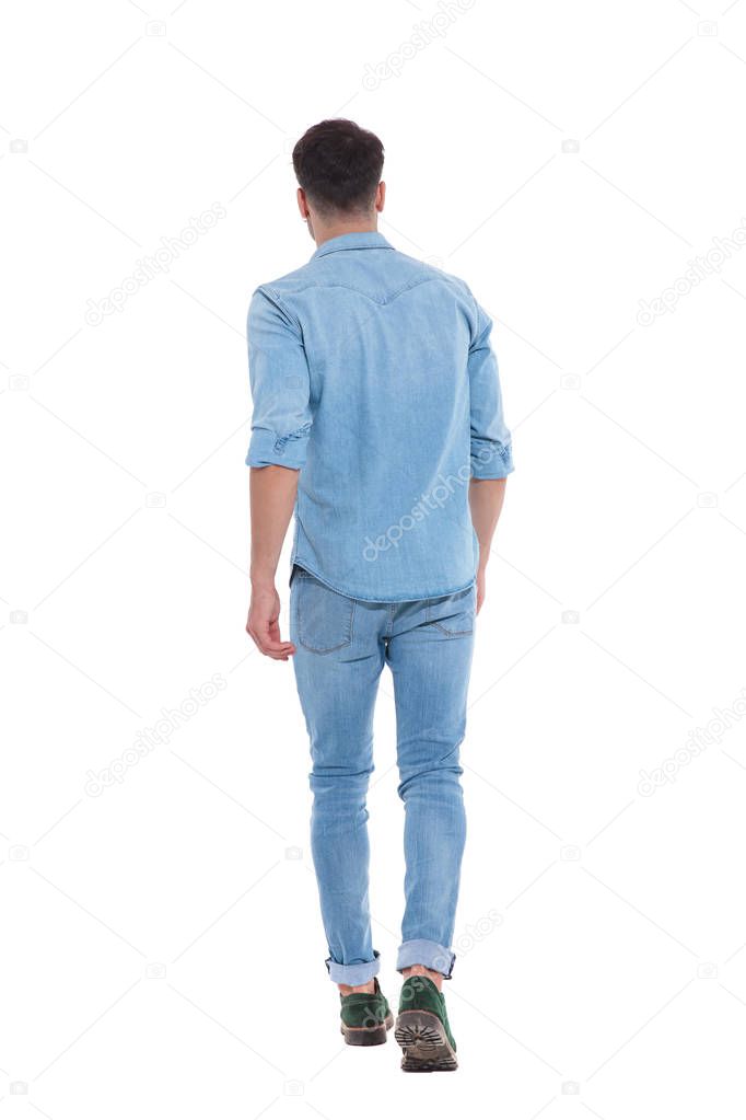 back view of young casual man wearing denim and walking