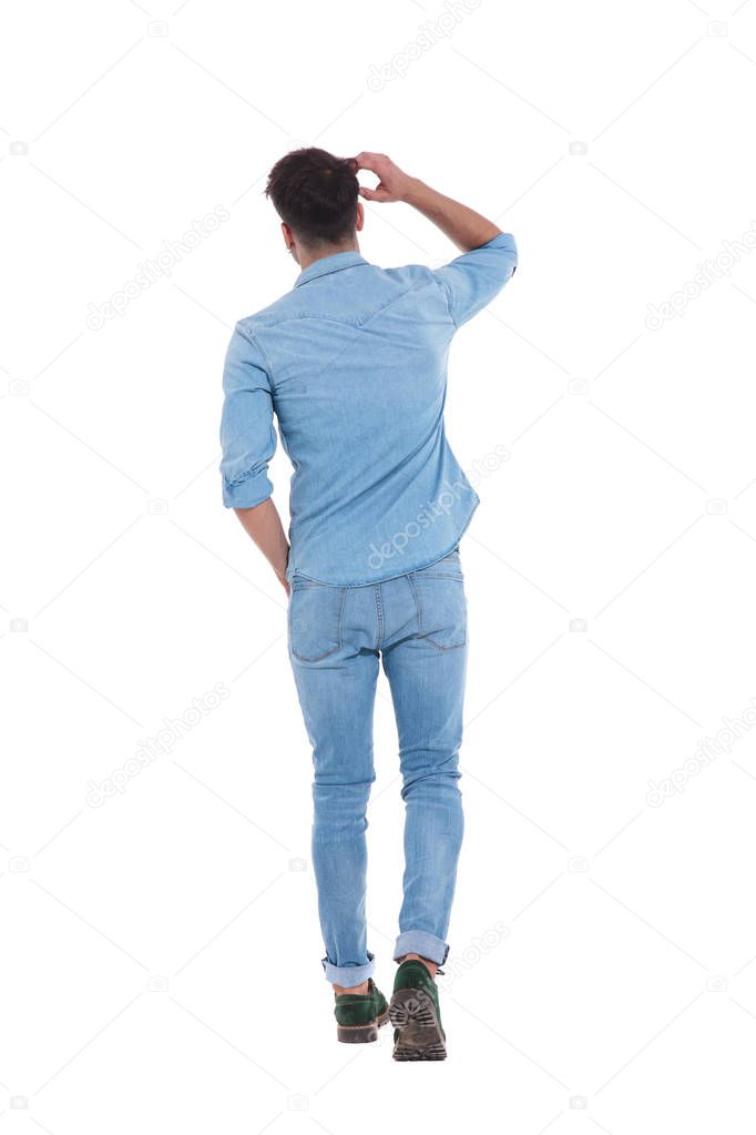 back view of young man wearing denim and thinking