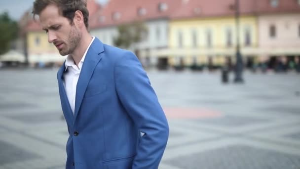 Undecided smart casual man starts to walk and then he greets someone in the street — Stock Video