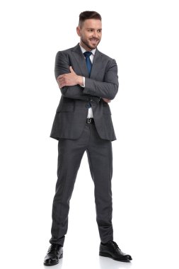 gülümseyen genç işadamı kolları katlanmış sid görünüyor ayakta