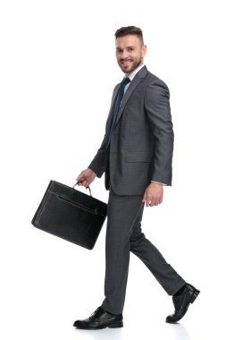 takım elbise ve kravat tutan bavul yürüyüş genç adam