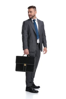 smilimg genç işadamı tutan evrak çantası onun üzerine bakar 