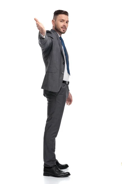 Visão lateral de um jovem empresário apontando a mão para a câmera — Fotografia de Stock