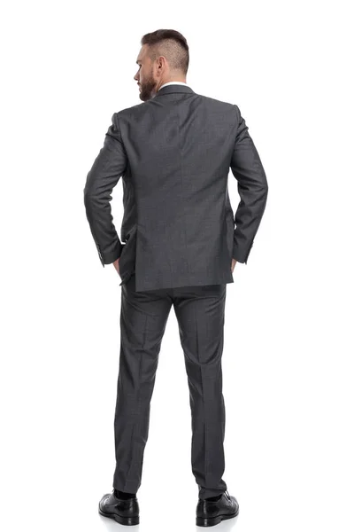 Vista posteriore del giovane uomo d'affari in piedi con le mani in tasca — Foto Stock